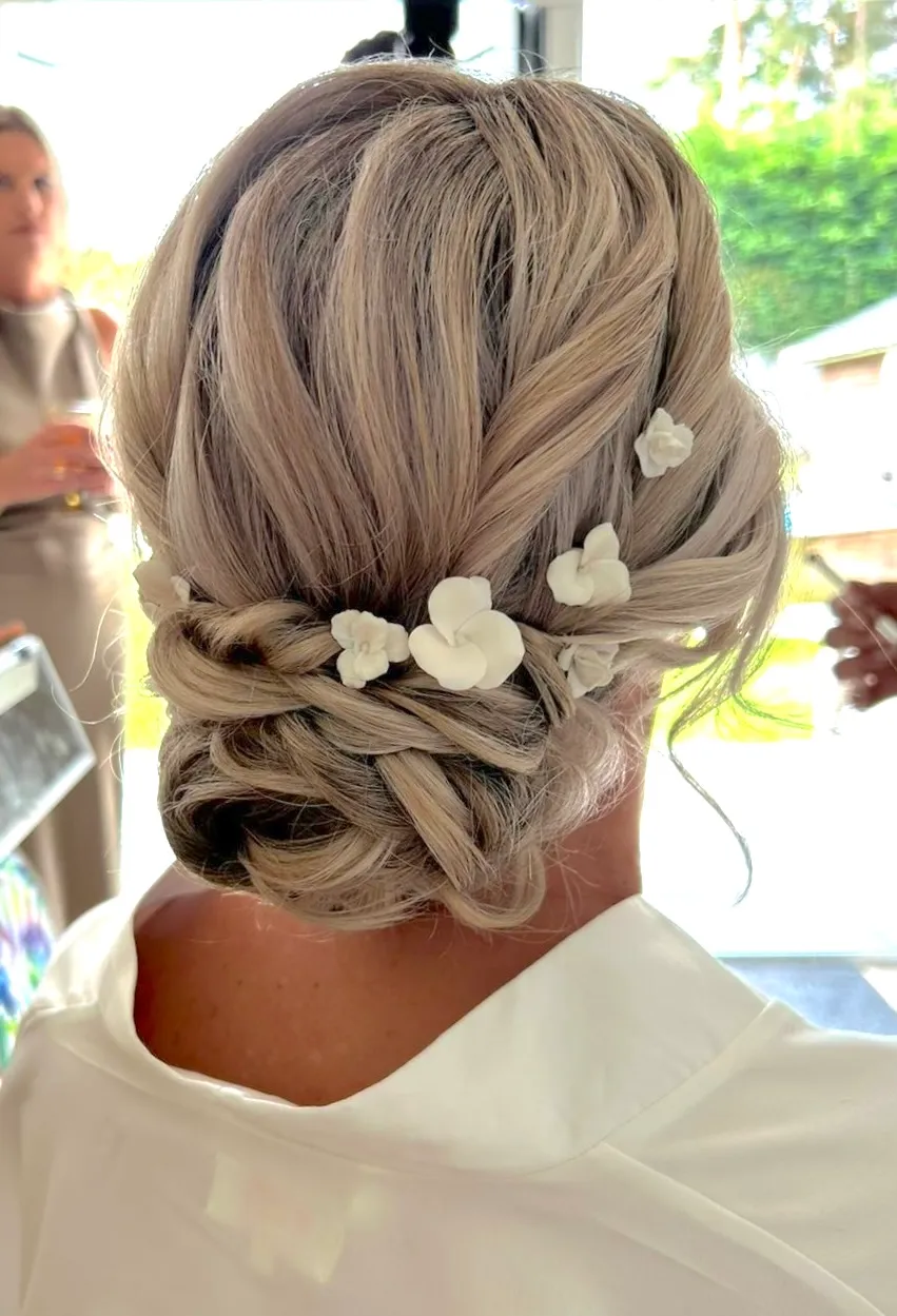 Porcelain flower hair pins decorating a braided bridal updo