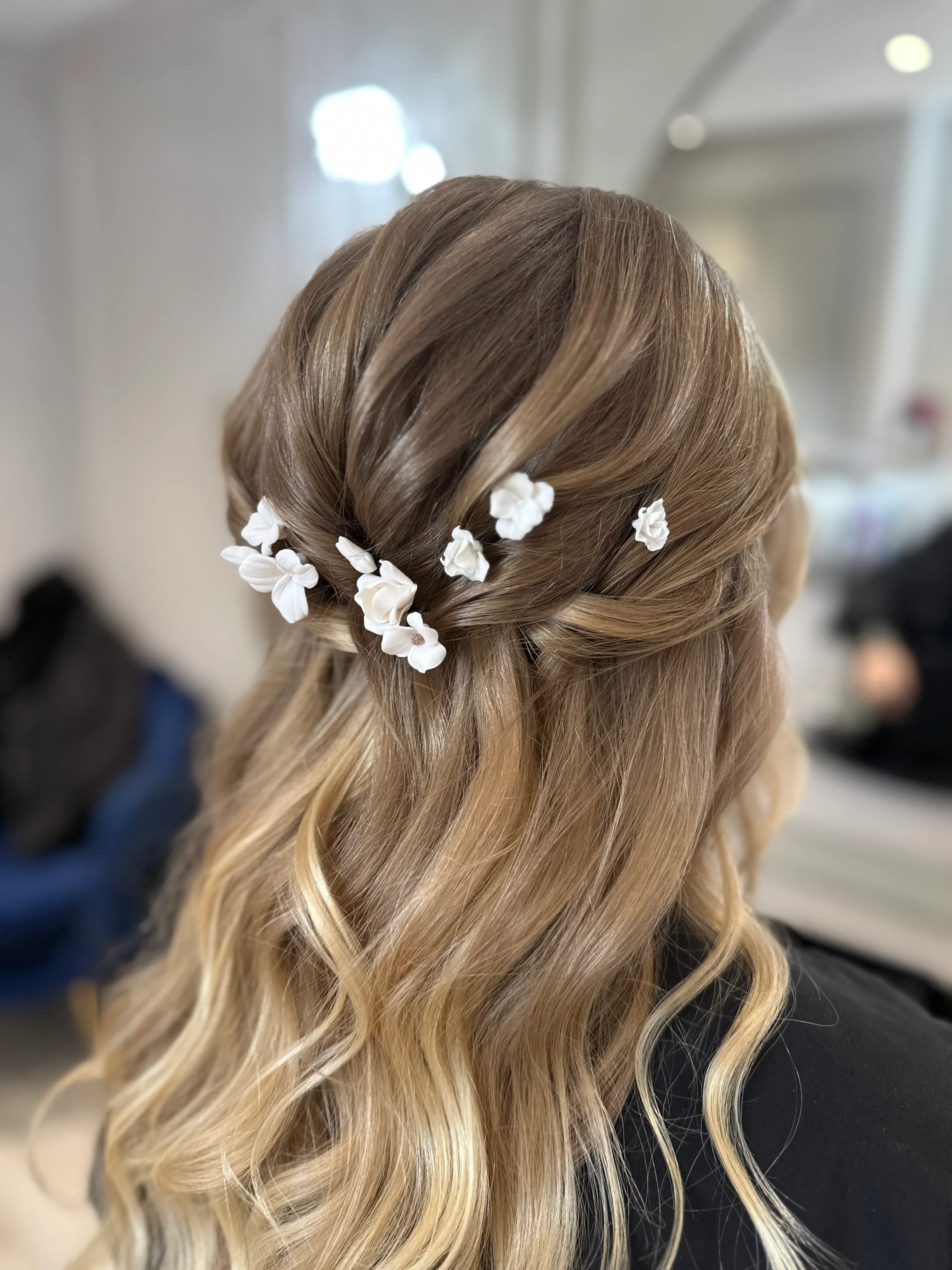 White Beauflora flower pins in a half-up bridal hairstyle